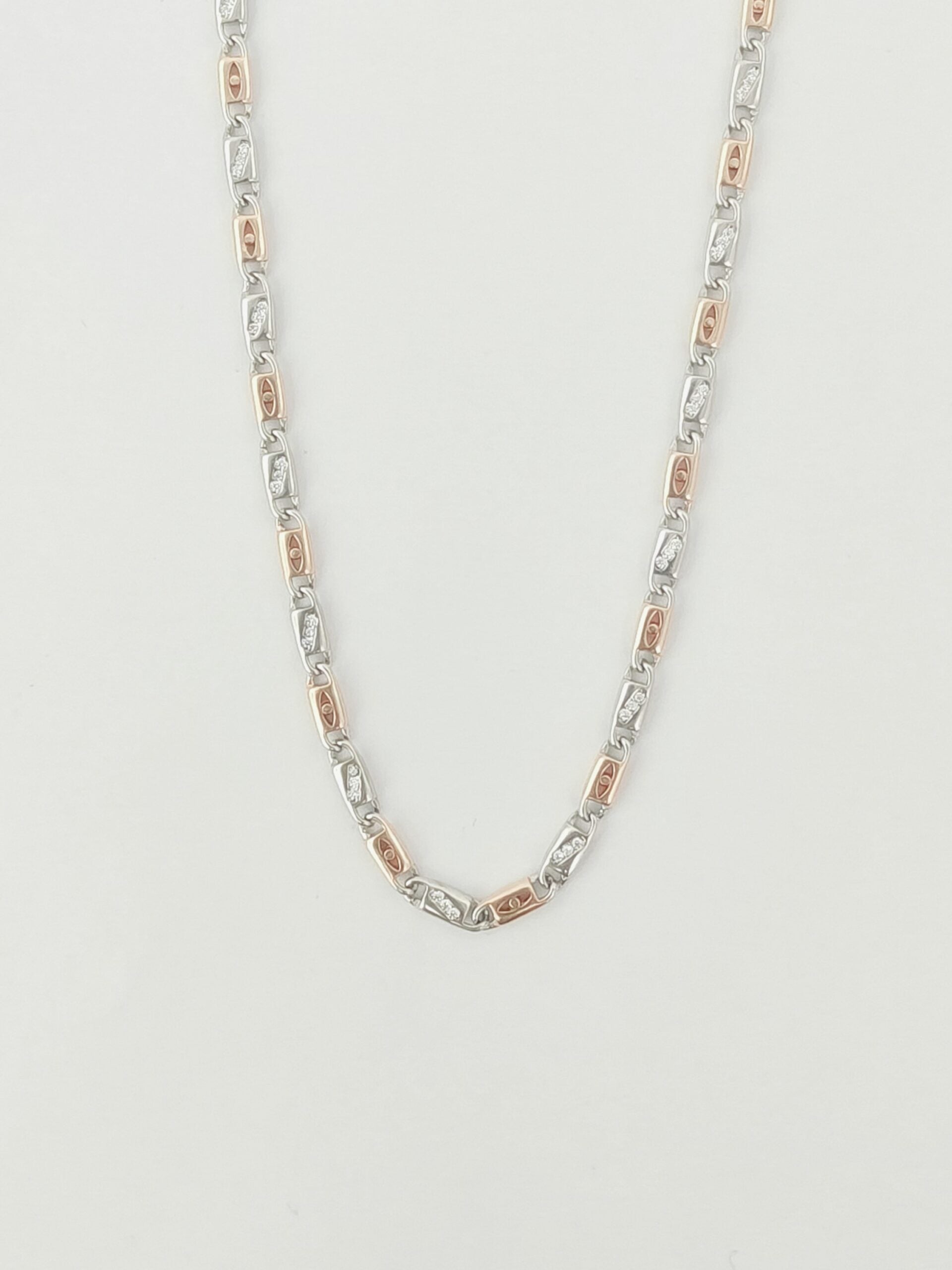 Silver and rose gold chain necklace on a light gray background
